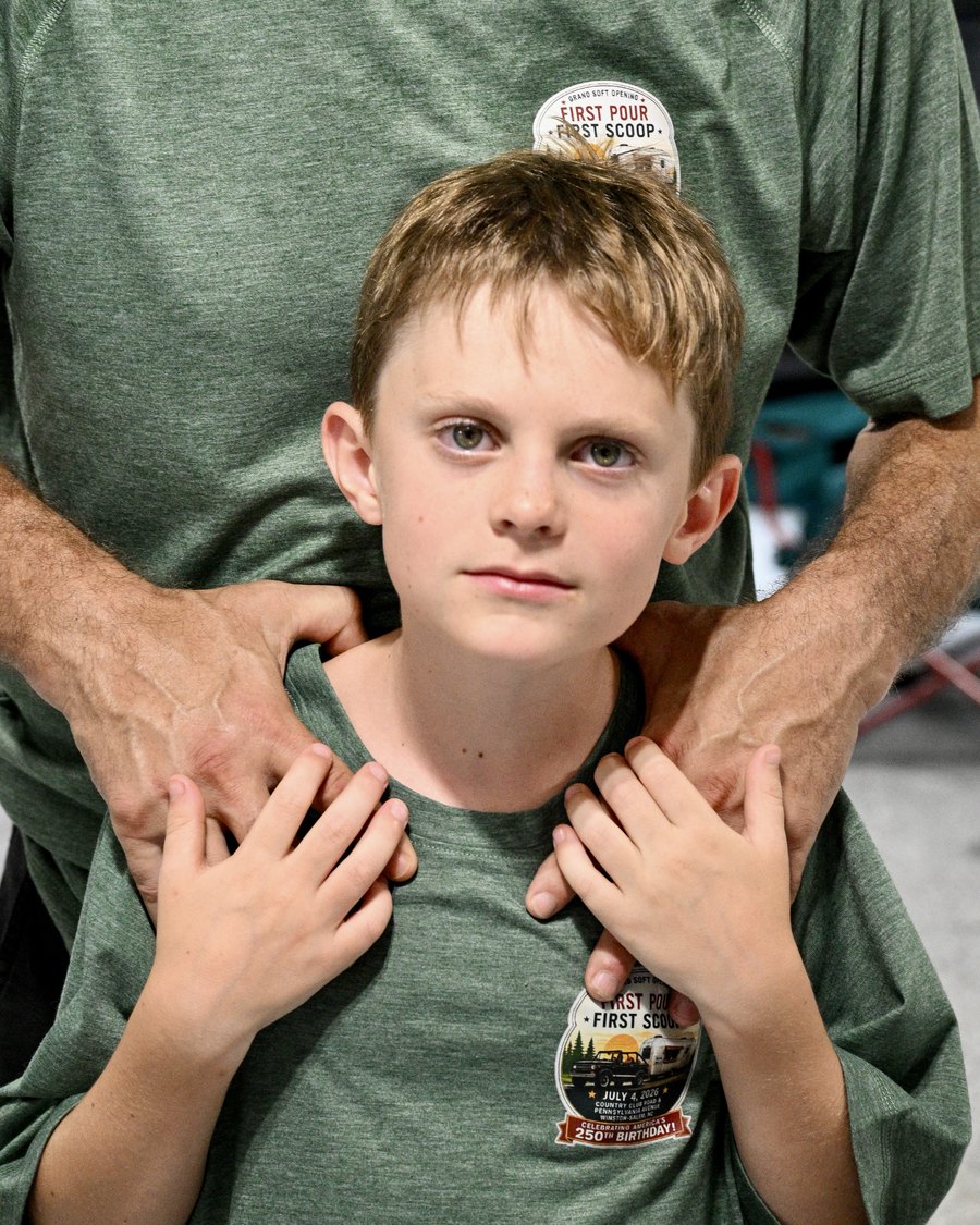 The Chief Sampling Officer in a Twin City Silver Bullet crew shirt with a First Pour First Scoop patch, photographed at the July 4, 2026 soft opening.