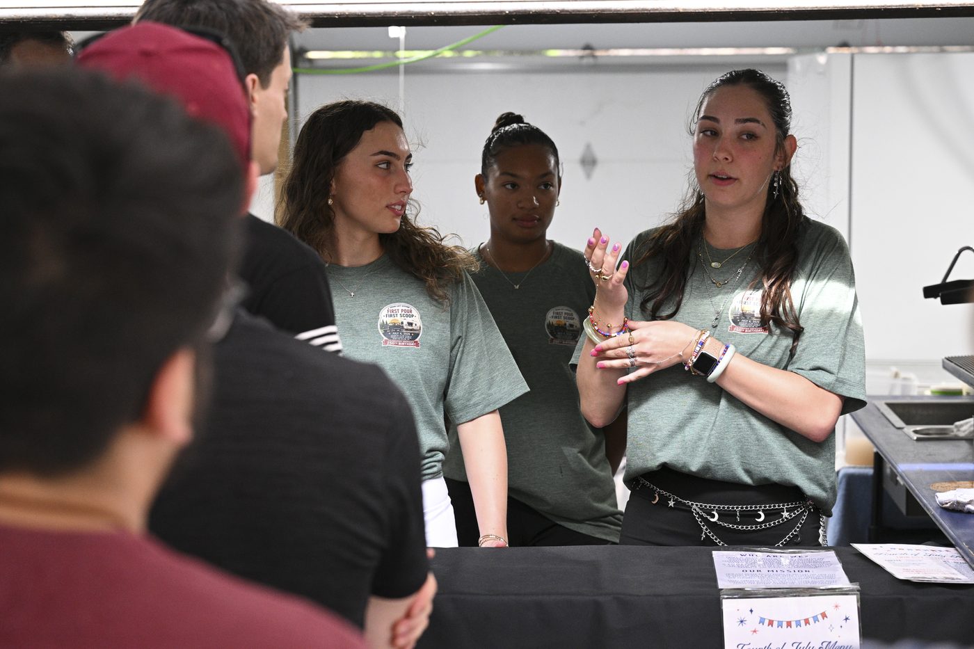 Twin City Silver Bullet crew members in green crew shirts talking with customers across the counter at the July 4, 2026 soft opening.